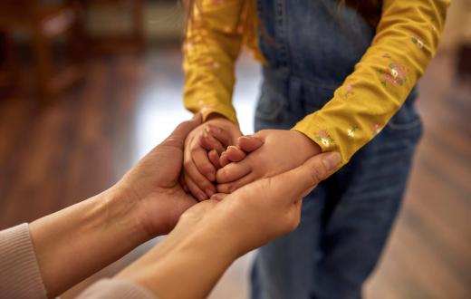 persona adulta cogiendo la mano de un niño/a