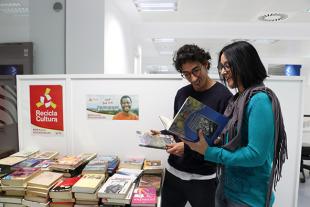 A man and a woman consulting the books on display