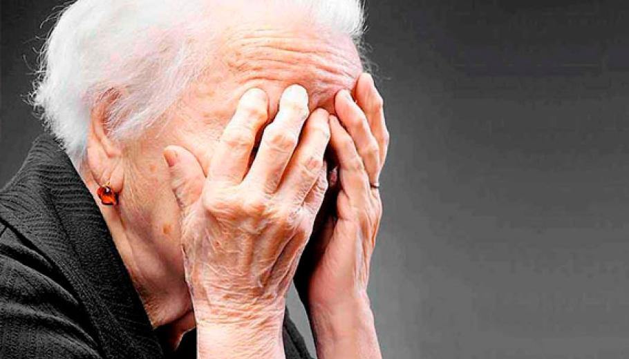 Una mujer mayor tapándose la cara con las manos